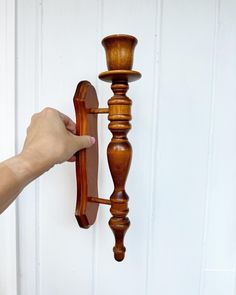 a person is holding the handle on a wooden door knob and it's pendulum