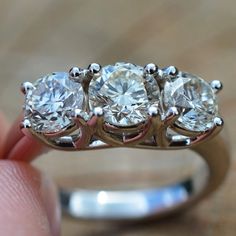 a three stone diamond ring is shown in this image