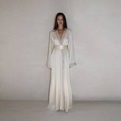 Robe Gown crafted in ivory silk , featuring a floor length silhouette , wrap design , tied waist , kimono inspired sleeves , velvet trim detailing , and train . This is the perfect evening gown. 100 % Silk Silky Robe Aesthetic, White Satin Pajama Dress, Luxury Silk Robe, Silk Dress Sleepwear, Wedding Night Outfit Brides, Silk Nightgown Aesthetic, Unique Bridesmaid Getting Ready Outfit, Silk Robe Aesthetic, Dressing Gown Aesthetic