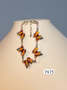 Butterfly charms have great details.  Three colors are combined to make this a lovely bracelet.  Charms are yellow with blue and red and joined with gold plated rings and chain,  Closure is a lobster claw. Bracelet measures approx. 6" to 7.5" Nickel Free Multicolor Metal Bracelets, Multicolor Nickel Free Metal Bracelets, Multicolor Enamel Jewelry With Lobster Clasp, Yellow Enamel Jewelry With Charms, Colorful Metal Jewelry For Gifts, Yellow Jewelry With Butterfly Charm For Gift, Colorful Metal Jewelry Gift, Colorful Metal Jewelry As Gift, Colorful Metal Jewelry As A Gift