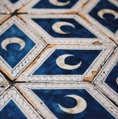 an intricately designed tile with crescents and stars in blue, white and gold