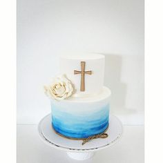 a white and blue cake with a cross on top