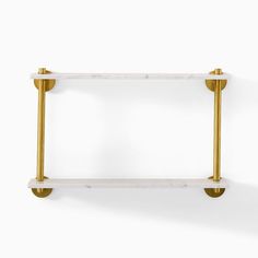 a white and gold shelf with two brass bars on the top, against a white wall