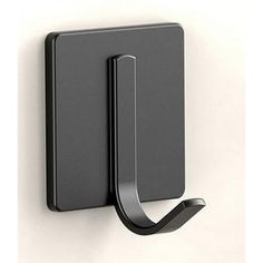 a black wall mounted hook on the side of a white wall with a curved handle