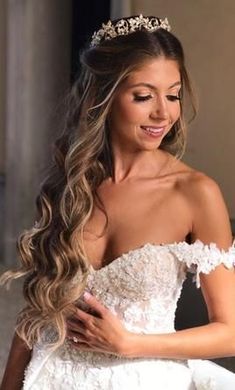 a beautiful woman in a wedding dress with a tiara on her head smiling at the camera