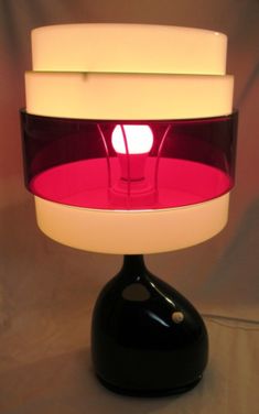 a black and white table lamp with red light