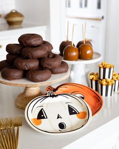 a table topped with chocolate covered donuts and other desserts on top of it