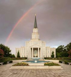 a large white church with a rainbow in the sky over it's front entrance