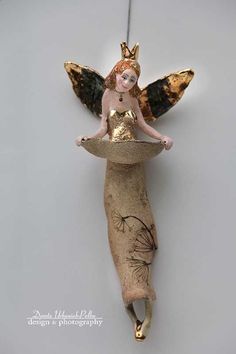 an ornament with a fairy sitting on top of it