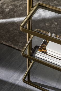 a stack of books sitting on top of a metal shelf next to a carpeted floor