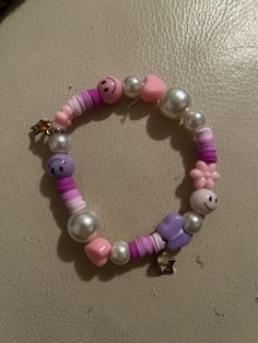 Pink and purple stretchy bracelet. Faux pearl, smiley, pony and charm beads. Fits small to medium sized wrists. Cute Purple Charm Bracelet For Friendship, Purple Beaded Charm Bracelet For Friendship, Cute Purple Bracelets With Colorful Beads, Cute Purple Bracelet With Colorful Beads, Trendy Purple Stretch Bracelet With Letter Beads, Fun Purple Bracelets For Friendship, Playful Beaded Purple Bracelets, Playful Purple Beaded Bracelets, Everyday Purple Beaded Stretch Bracelet