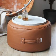 a small bottle sitting on top of a leather ottoman