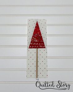 a red and white christmas tree on top of a piece of paper with the words santa claus written on it