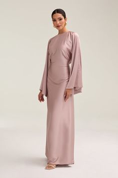 Indulge in luxury with the Batool Satin Maxi Dress. Its loose wide sleeves and lustrous satin fabric exude elegance, while the adjustable tie waist flatters your figure. Versatile design makes it perfect for Eid and beyond. Elevate your style with this exclusive piece. Model is 5'7 wearing size XS/58" Bridesmaid Long Sleeve Dresses, Modest Maxi Dress Hijab Styles, Long Sleeves Designs For Dresses, Hijabi Bridesmaid Dresses, Elegant Hijab Dress, Satin Modest Dress, Satin Dresses Hijab, Hijab Long Dress, Satin Dress Hijab