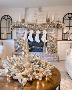 a living room decorated for christmas with stockings on the fireplace