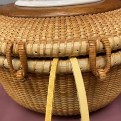 a wicker basket sitting on top of a table with a yellow ribbon around it