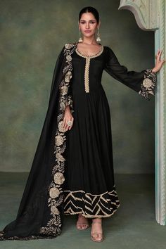 Premium Silk Black Anarkali Gown with Heavy Embroidered Dupatta | Luxury Ethnic Wear Elevate your wardrobe with this stunning Black Anarkali Gown, crafted from premium silk and paired with a heavily embroidered dupatta. Exquisite Silk Elegance: This floor-length Anarkali gown is made from rich, lustrous silk that drapes beautifully, exuding timeless grace and sophistication. The luxurious fabric ensures a smooth, elegant flow with every step, making it perfect for special occasions. Key Features Organza Dress Indian, Women Indian Wear, Black Organza Dress, Black Anarkali, Silk Anarkali, Gown With Dupatta, Abaya Style, Utsav Fashion, Anarkali Gown