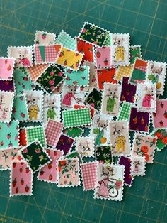 a pile of patchwork pieces sitting on top of a green cutting board next to a knife