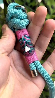 a hand holding a blue and pink paracorre with an arrow on it's end