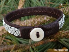 "Spun pewter silver braid, hand stitched on soft reindeer leather or lambskin, and completed with a naturally shed hand carved reindeer antler button. Width: approx. 1 - 1,2 cm (0,4\"-0,47\"). Ships in a nice handmade gift box. Design: MIDGARD - The human world; Earth and one of the Nine Worlds in Norse mythology. LEATHER COLORS AND STYLES: Please see last photo - 30 colors to choose from. SIZE: Please measure your wrist and add 1 cm (0,4\"), for a perfect snug fit. The soft leather will stretch Handmade Viking Leather Bracelet, Adjustable Viking Leather Bracelet, Adjustable Leather Viking Bracelet, Adjustable Viking Style Leather Bracelet, Antler Buttons, Leather Colors, Gift Box Design, Viking Bracelet, Reindeer Antlers