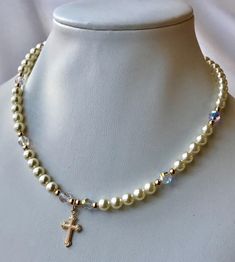 "The list is for the first picture. This is an absolutely beautiful necklace, is the perfect gift to a princess for her first communion, baptism, christening or flower girl. This beautiful and elegant necklace features with swarovski crystal cream pearls (5mm) and crystal AB, 14Kt gold filled beads, cross, and extender chain. This necklace measures 14\" inches long and has a 2 inches extender chain with dangling pearl. All parts are 14Kt gold filled. Available in white and cream/ivory peal color First Communion Pearl Drop Jewelry, Elegant Pearl Jewelry For Baptism, Pearl Charm Jewelry For First Communion, Pearl Jewelry For Baptism With Round Beads, Spiritual Pearl Jewelry For Baptism, Elegant Pearl Jewelry For Confirmation, Gold Pearl Jewelry For Baptism, Elegant Personalized Necklace For First Communion, Pearl White Spiritual Jewelry For First Communion