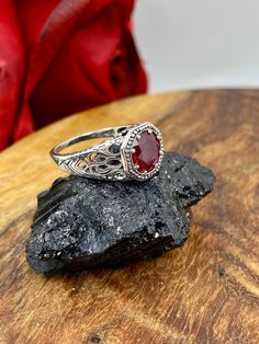 Natural Red Ruby Ring  New Vic Design#11 This is a stunning Edwardian/Victorian estate reproduction in sterling silver filigree with a natural 1.38ctw ruby gemstone. The red ruby is 8mm in diameter. The inside of the band is marked 925 for sterling. The natural ruby is heat and color treated, quality i1-i3.  Notice the beautiful craftsmanship of the silver filigree setting and band. This is an ornate and detailed ring. This is a lovely rendition of an antique filigree ring, and it is ready to we Red Victorian Filigree Ring With Gemstone, Ruby Filigree Ring As Gift, Ornate Ruby Ring With Intricate Design, Victorian Ruby Ring With Birthstone, Victorian Ruby Birthstone Ring, Heirloom Style Red Ruby Ring With Filigree, Heirloom Red Filigree Ring, Antique Ruby Filigree Ring, Victorian Ruby Ring With Filigree