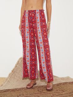 For those partial to a St Barts sojourn, the flouncy silhouettes of the Marguerite story radiates gypset chic with a cornflower motif lush with ruby hues and accented with ditsy denim blues across cotton lenzing blends. Subtle wide leg, full length pant with soft elastic waist. Featuring functional side pockets and engineered print placement to elongate the legs. Red Bohemian Bottoms For Vacation, Bohemian Red Bottoms For Vacation, Bohemian Floral Print Trousers, Red Boho Print Bottoms For Summer, Red Boho Print Summer Bottoms, Bohemian Red Wide Leg Bottoms, Bohemian Wide-leg Floral Print Bottoms, Bohemian Wide Leg Bottoms With Floral Print, Red Bohemian Wide Leg Pants For Summer