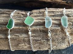 four pieces of sea glass on a piece of wood