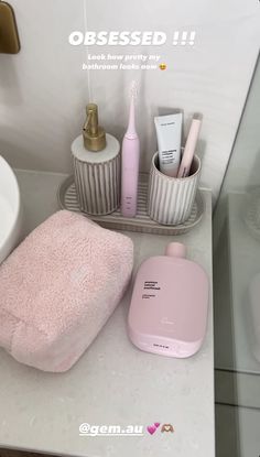 a bathroom counter with pink items on it and the words obsesed written above them