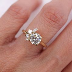 a woman's hand with a diamond ring on top of her finger and an engagement band