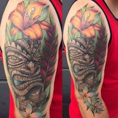 a man's half sleeve with flowers and leaves on his left arm, the other half