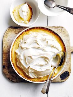 a bowl filled with whipped cream on top of a cutting board