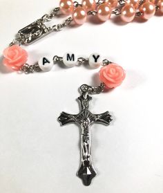 Hello and welcome. This rosary can be personalized with a baby's name or initial letters, ideal count of letters is 3 to 5. I recommend to choose a short version of baby's name for better look. Necklace measures 21 inches, it can grow with baby or can be put away as a keepsake memory for later. This will make a perfect baptism/ christening gift! Spiritual Pink Jewelry For Birthday, Mother's Day Gift Rosary With 8mm Beads, Personalized Pink Beaded Jewelry, Personalized Cross Rosary Bracelet For Baptism, Adjustable Rose Gold Rosary As Gift, Personalized Pink Rosary Bracelet For Baptism, Personalized Spiritual Rosary Gift, Personalized Silver Rosary For First Communion, Mother's Day Rosary With 8mm Beads