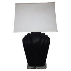 a black table lamp with a white shade on the top and bottom part of it