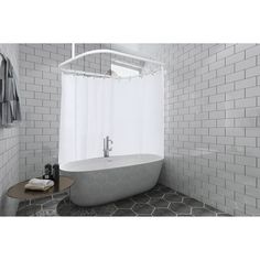 a bath tub sitting next to a shower curtain in a white tiled bathroom with hexagonal tiles on the floor