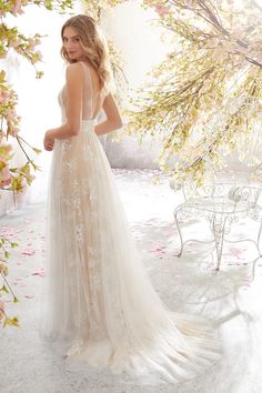 a woman in a wedding dress standing next to flowers