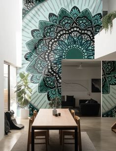 a dining room with a table and chairs in front of a large mural on the wall