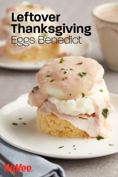 an egg benedict sandwich on a plate with a cup of coffee in the back ground