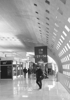 black and white photo of people walking through an airport