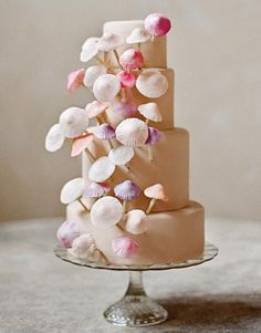 a three tiered cake decorated with pink and white flowers