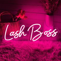 a pink neon sign that says,'cash boss'in front of a basket with flowers