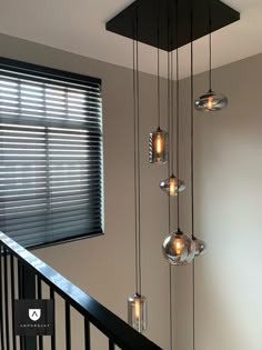 a bunch of lights that are hanging from a rail in a room with blinds on the windowsill