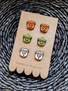 three little pumpkins are sitting on top of a piece of paper with some sort of earring