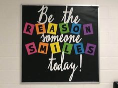 a black and white sign that says be the reason someone smiles today with colorful blocks on it