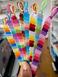 a person holding up some colorful crocheted items