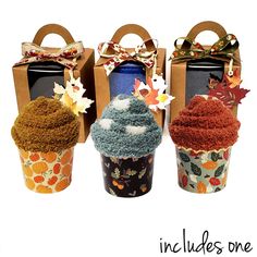 three cupcakes are decorated with fall leaves and decorations, one is made out of paper