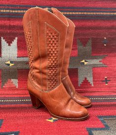 From Blackbird Vintage of Sedona, Arizona  This is a great pair of Vintage Ladies brown leather Boots,size 6.5, and maybe best for a narrow foot. Made In Brazil, circa 1970s. they have a great woven leather design and convenient side zipper closures for easy on/off. Tacco leather insoles which are made in Germany. They are in worn vintage condition. Normal signs of wear for their age, such as  scuffing, spotting, nicks and creasing. Wear to the heels and soles. inner heel lining on one boot is puckering a bit. Please look at all photos closely. Unsure of the brand however "Janis" is stamped inside the boot. -Heel height: 3" -Height of boot:13.5", inclusive of heel height -Heel to toe: 9.25" -insole: 9.25 inches -Width, widest part of sole:3.1/8" Please visit our Brick and Mortar location w Brown Leather Heeled Boots For Western-themed Events, Fall Boots With Woven Leather And Round Toe, Fall Woven Leather Boots With Round Toe, Fall Boots With Woven Leather, Vintage Fitted Heeled Boots For Rodeo, Brown Heeled Boots With Leather Sole For Ranch, Brown Woven Leather Boots, Leather Knee-high Heeled Boots For Rodeo, Casual Leather Heeled Boots For Rodeo