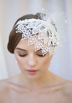 a woman wearing a white head piece with lace on it and pearls in the hair