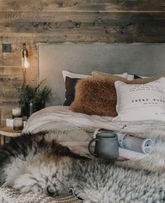 a bed that has some pillows and blankets on top of it, next to a lamp