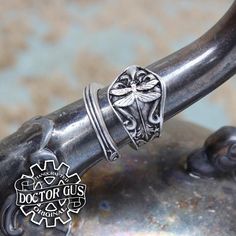 This is an adjustable wrap style Dragonfly ring.A fantastic Ring sculpted by yours truly, Doctor Gus! Wear this ring to make a bold statement everyday. Or get one to add that perfect final touch to your next cosplay. Each one is unique and sure to start a conversation!—————You will receive one Ring as pictured.Available in multiple sizes. Our rings are also adjustable. So you can pick your size and make that final adjustment for the perfect fit if you need to.It is unisex and looks great on ever Handmade Silver Adjustable Butterfly Ring, Handmade Adjustable Butterfly Ring, Adjustable Vintage Sterling Silver Butterfly Ring, Vintage Adjustable Sterling Silver Butterfly Ring, Unique Adjustable Open Butterfly Ring, Adjustable Nickel-free Butterfly Ring, Handmade Adjustable Metal Snake Ring, Adjustable Handmade Metal Snake Ring, Symbolic Adjustable Stackable Open Rings